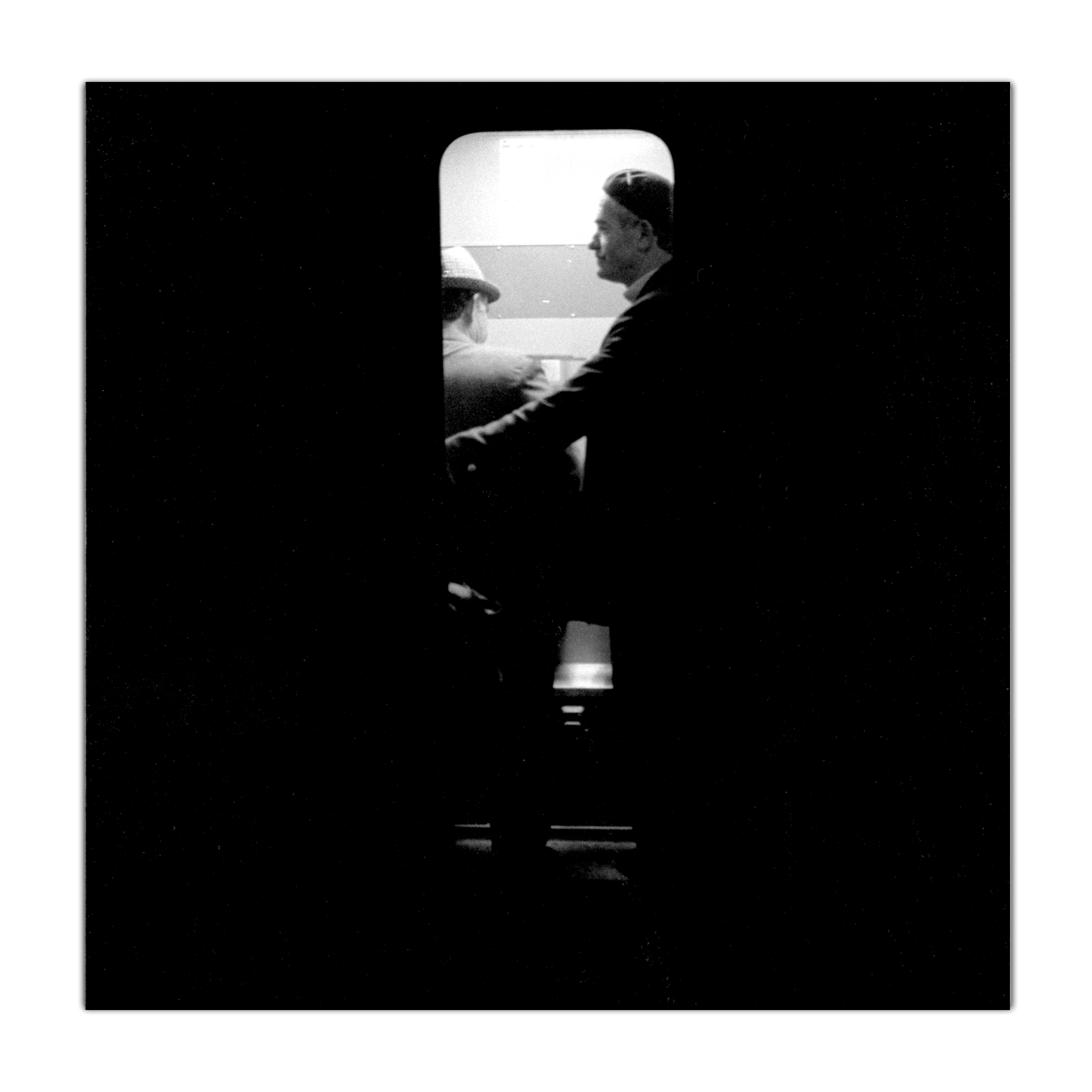 Men in underground train, East Berlin by Cambridge Jones